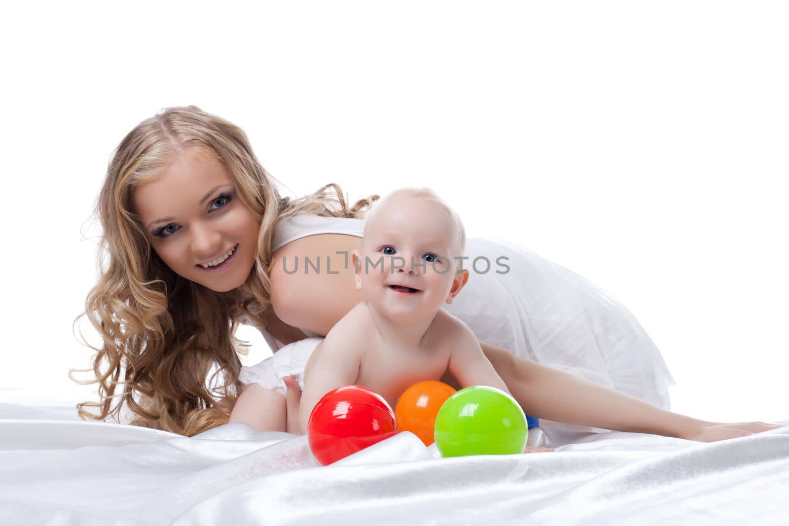 Portrait of happy mother and baby in bed. Isolated on white