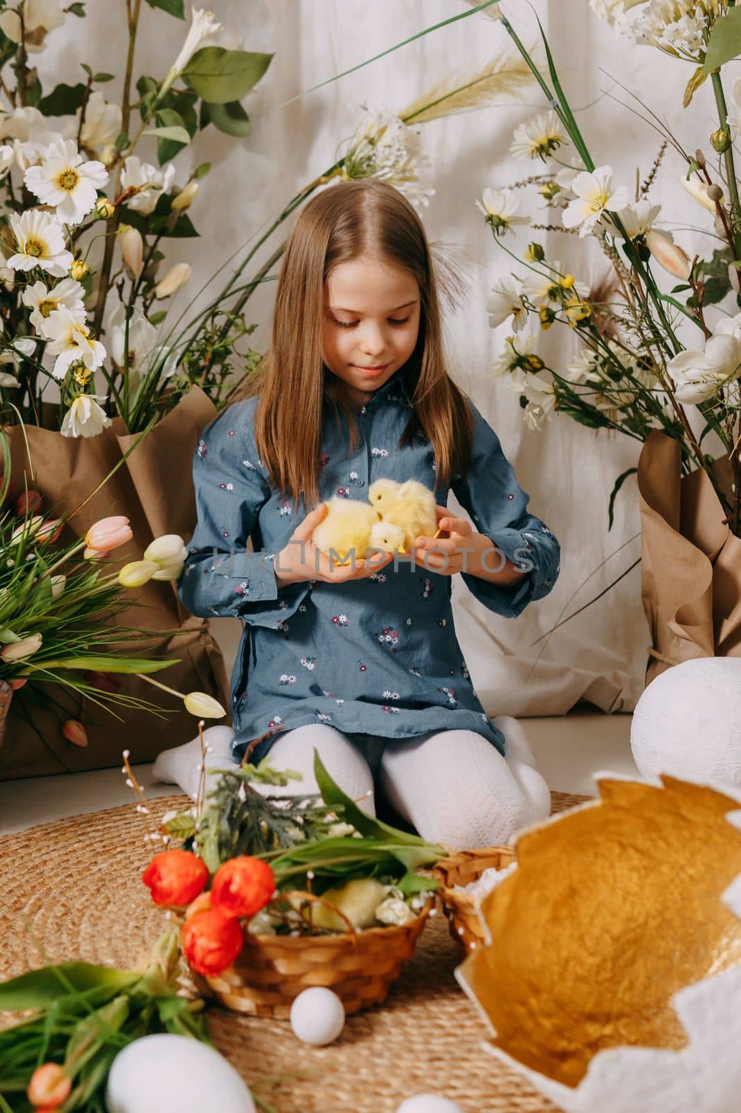 Two girls in a beautiful Easter photo zone with flowers, eggs, chickens and Easter bunnies. Happy Easter holiday. by Annu1tochka