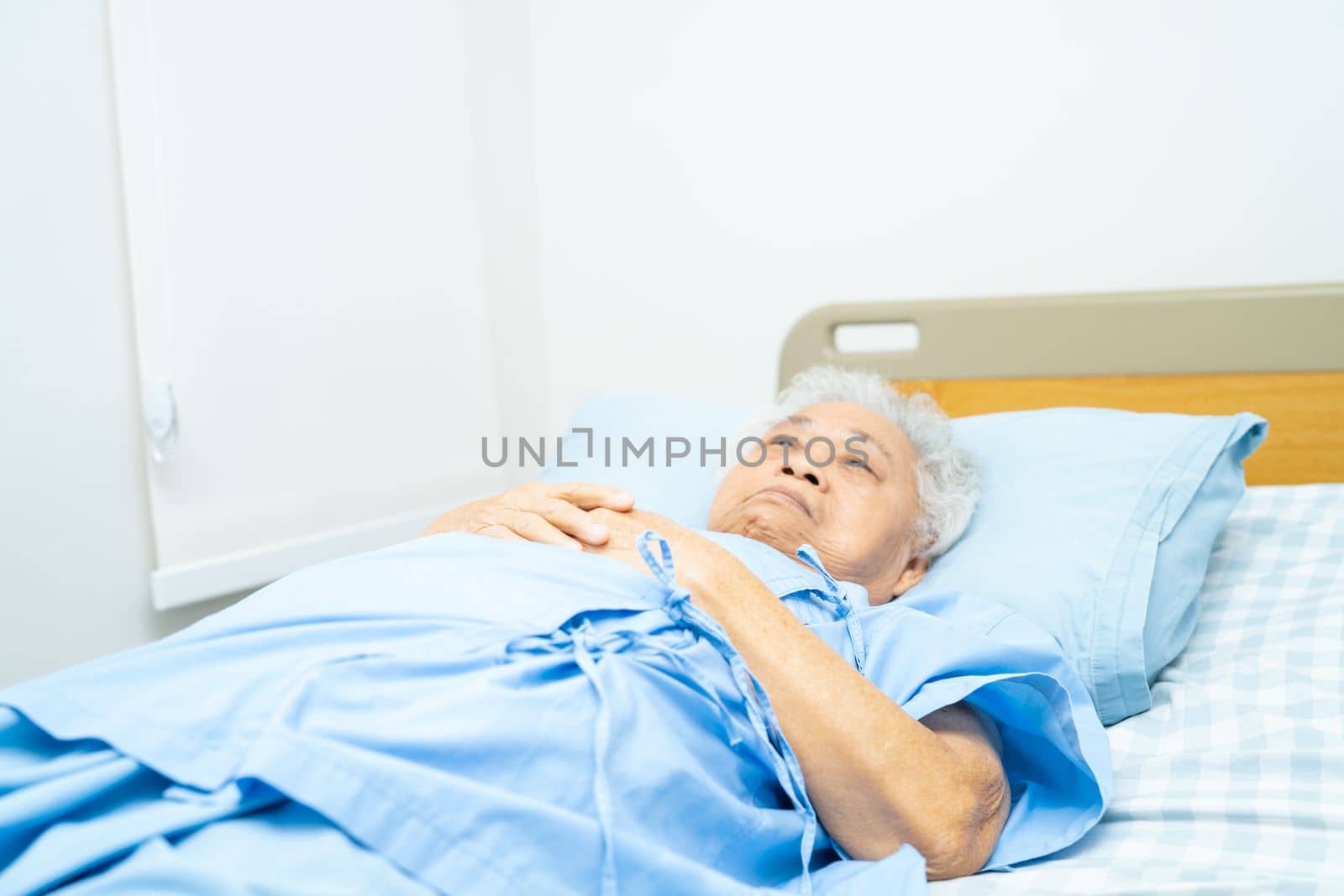 Senior or elderly old lady woman patient lie down in nursing hospital ward, healthy strong medical concept. by pamai