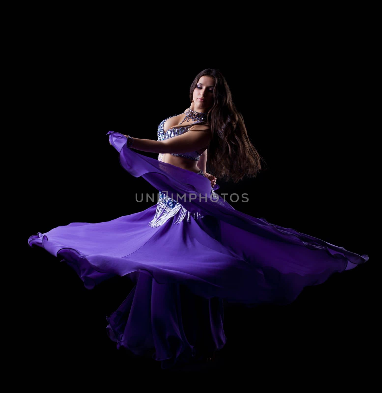 Brunette young woman dancing oriental dance by rivertime