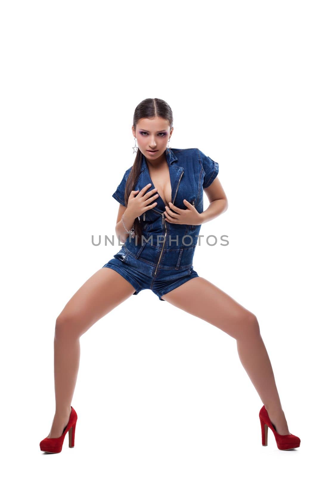 Full length portrait of sexy brunette young woman in denim overalls. Isolated on white