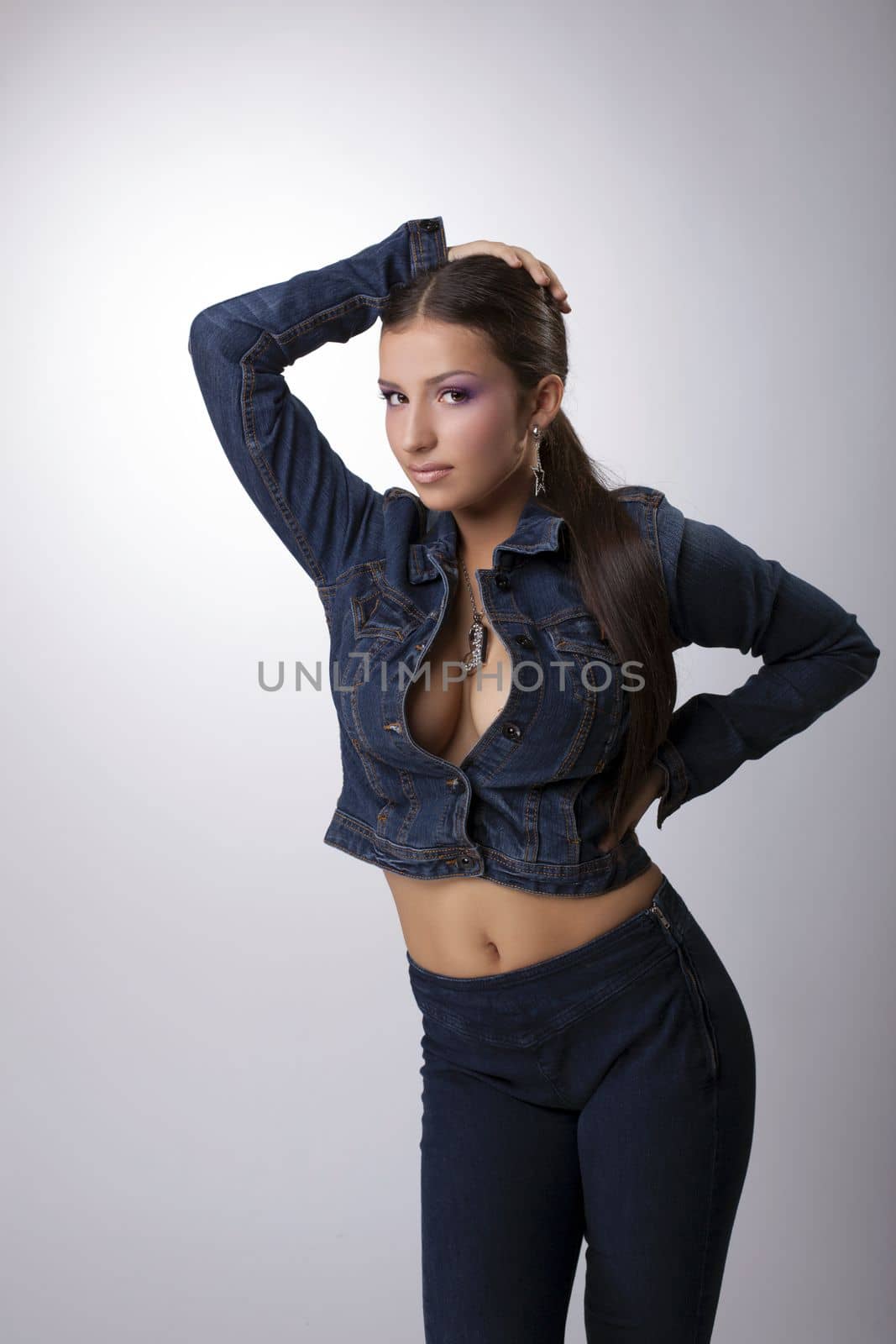 Studio portrait of brunette woman in jacket and jeans