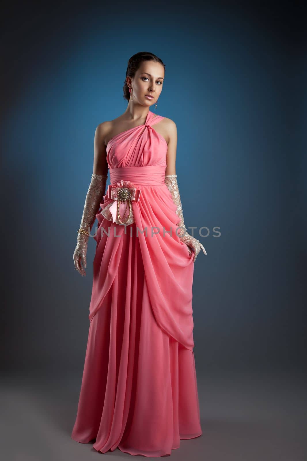 Beauty woman posing in rose fashion evening portrait on blue