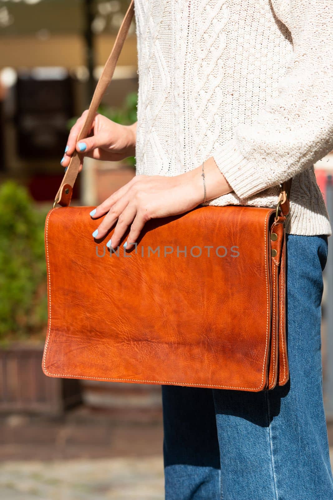 close-up photo of light brown messanger leather bag on mans shoulder by Ashtray25