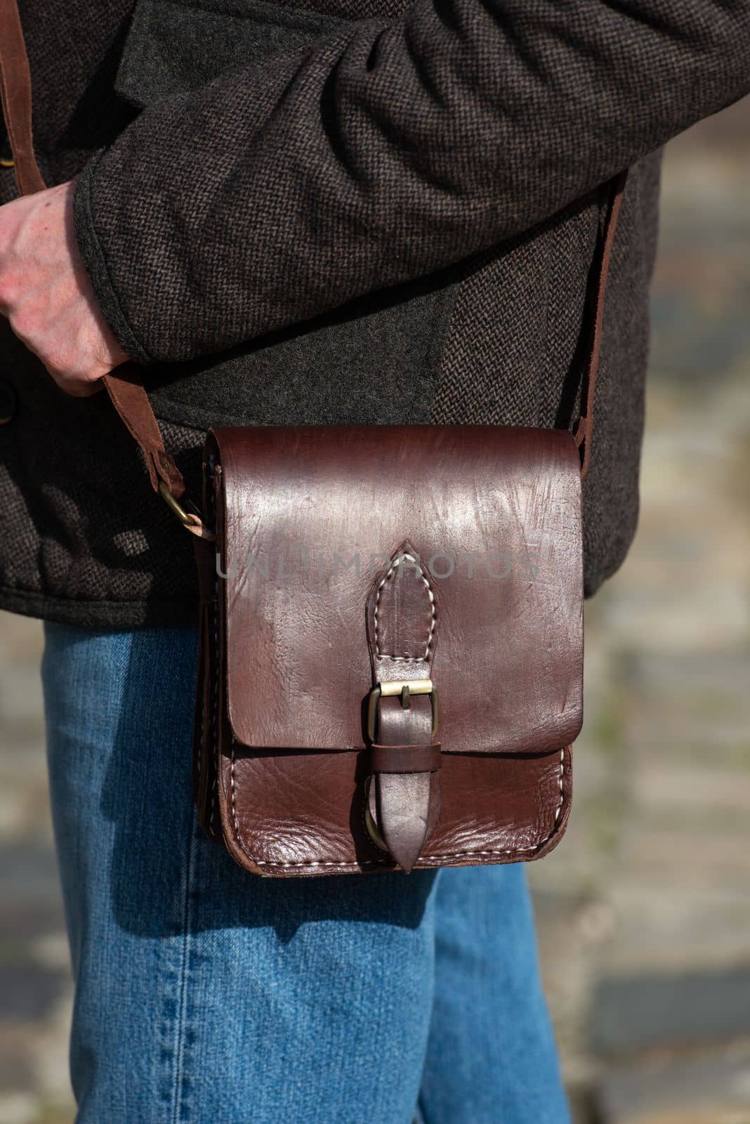 close-up photo of brown messanger leather bag on mans shoulder by Ashtray25