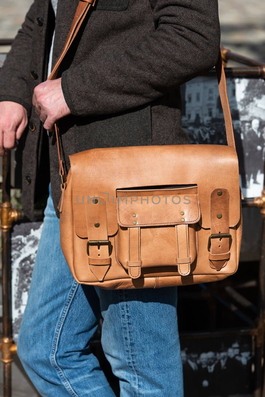 Man with a yellow leather briefcase with antique and retro look. Outdoors photo.