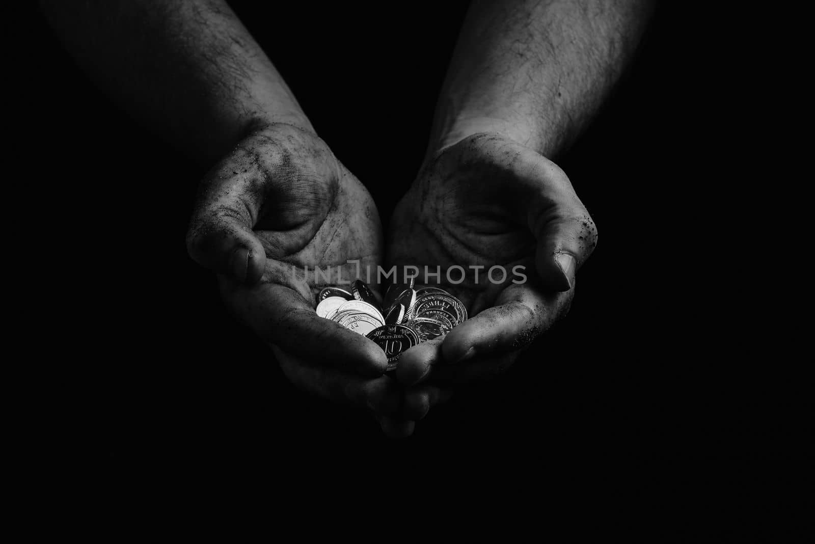 poverty in Ukraine. Black and white. Dirty hands of a poor homeless man holding Ukrainian hryvnias in coins by gulyaevstudio