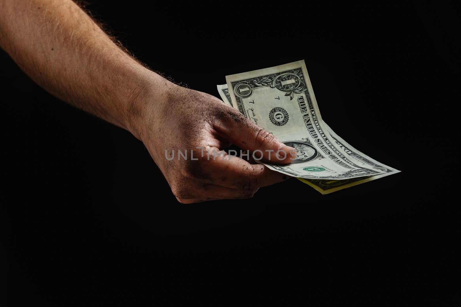 Conceptual image of dirty hands holding a few dollars. Financial crisis. Collapse in the economy. by gulyaevstudio