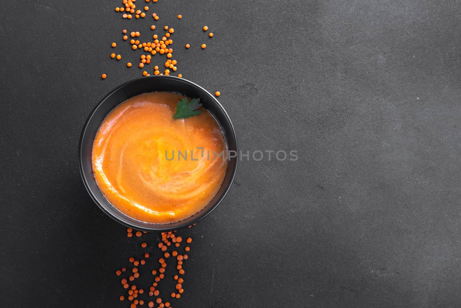 Mashed red lentil soup on a dark background view from above. Copy space for text, writing the recipe, ingredients by gulyaevstudio