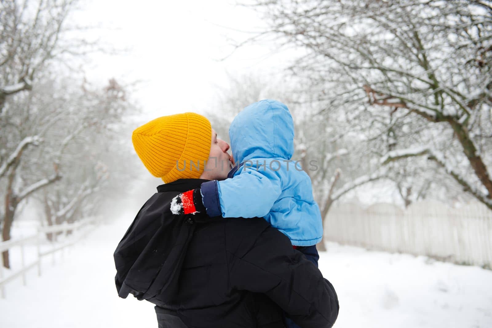 Dad holds his son in his arms in winter. Dad and his son. Dad and his baby. Winter fun. The happy childhood of a young child
