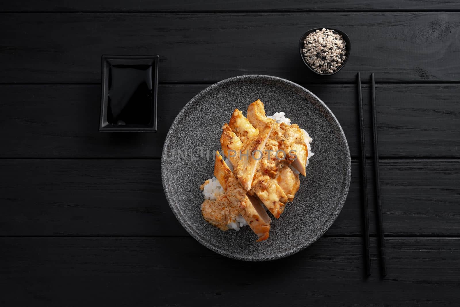 Nasi Hainan or Hainan chicken. Hainan chicken rice is a dish of poached chicken and seasoned rice. Top view and dark wooden background