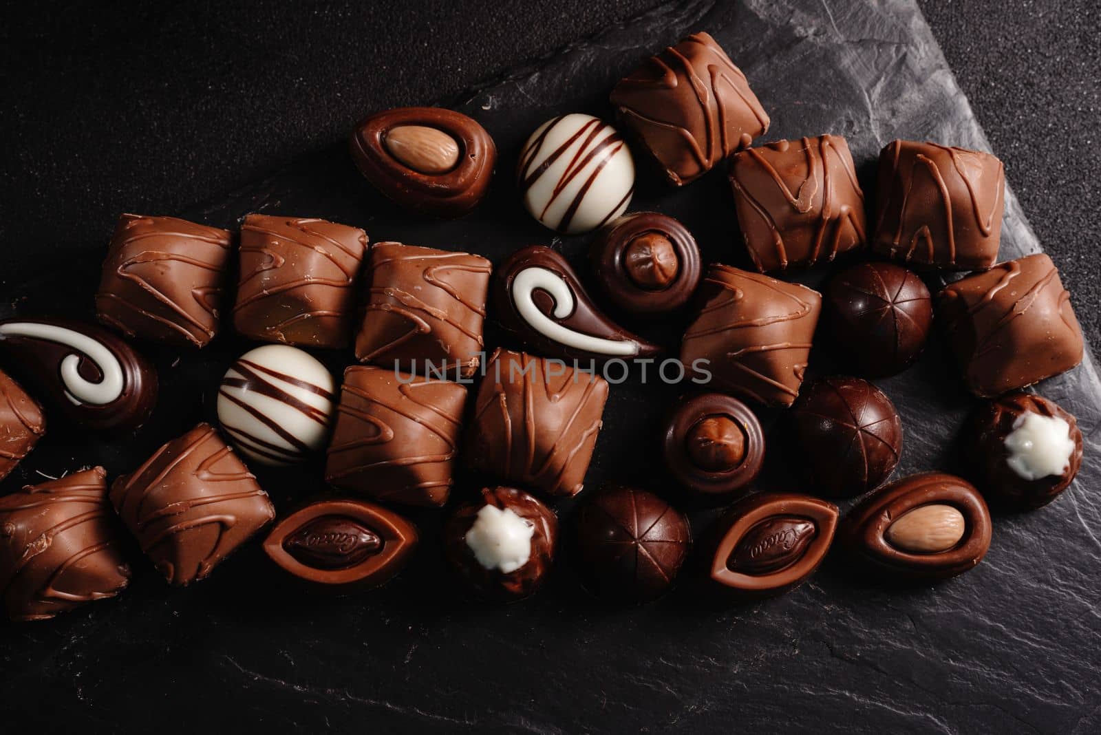 chocolate candies with various fillings, sweet food background. mix and match set of different candies. chocolates with different fillings, sweet food background. Copy space