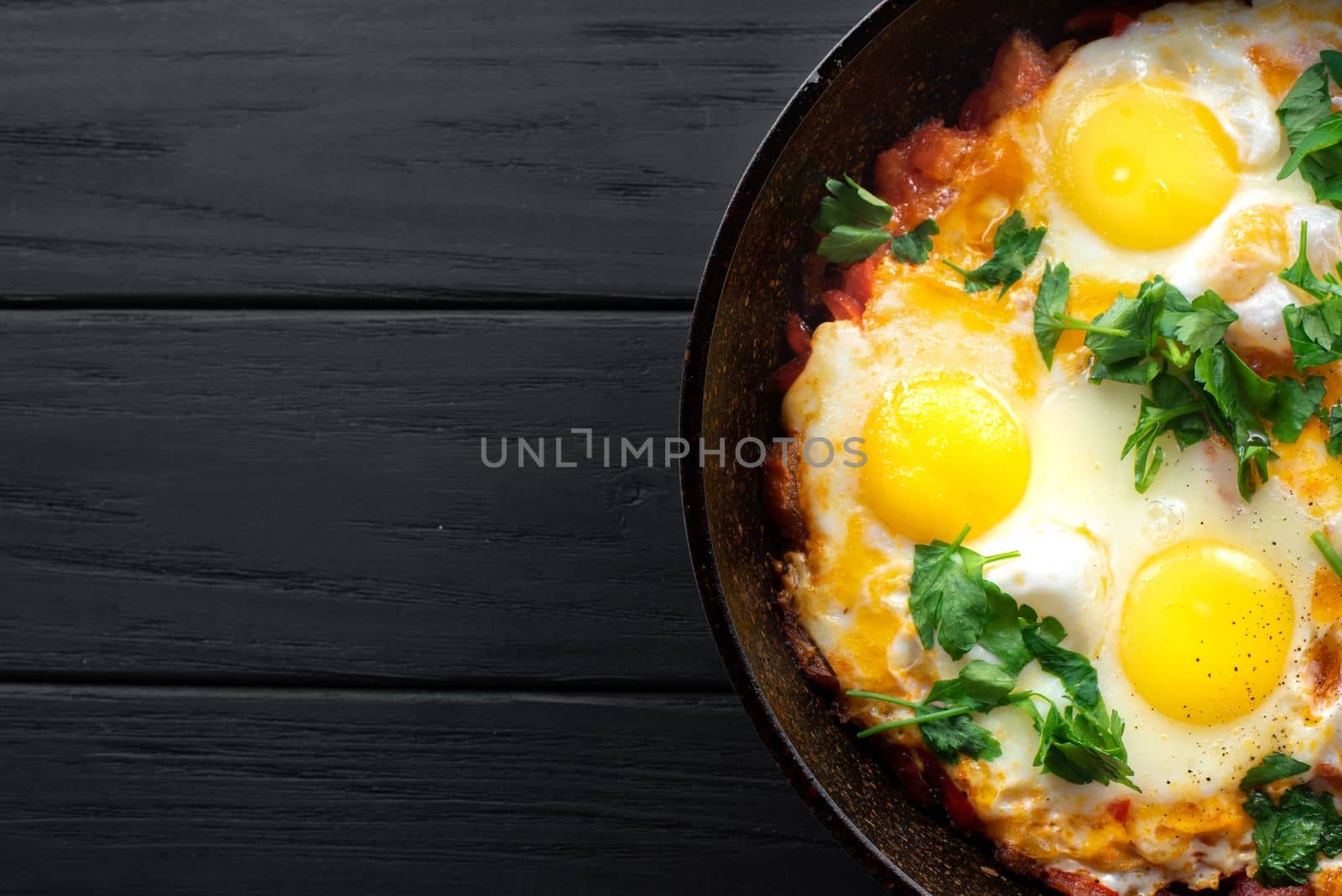 Jewish scrambled eggs in a frying pan. Traditional shakshuka eggs. Copy space, top view by gulyaevstudio