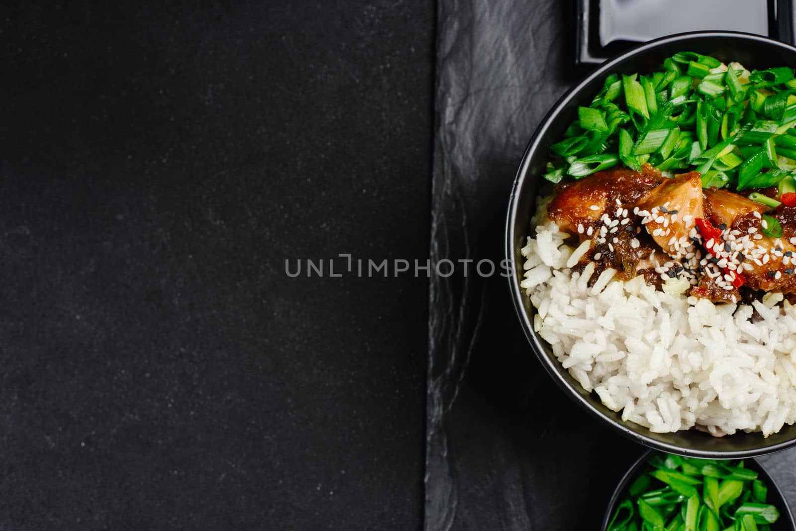 teriyaki chicken rice bowl - asian food style. Asian food. Thai food. Rice with chicken and green onions on a dark background. Chinese food