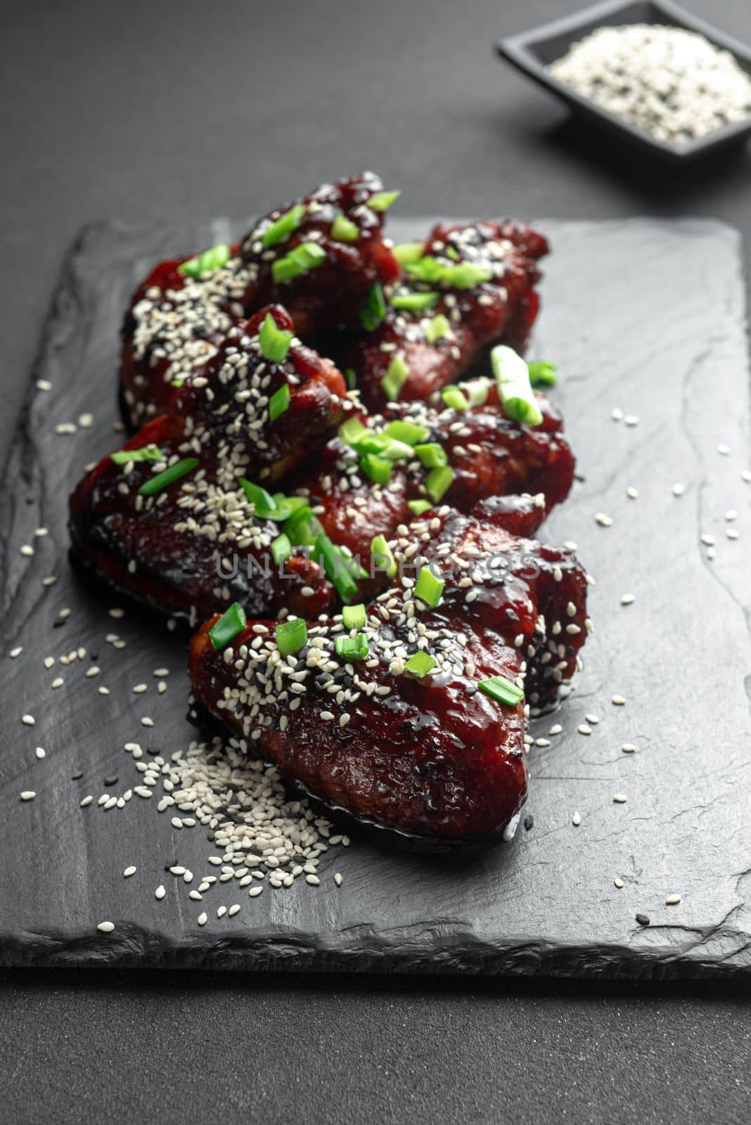 Chicken wings. Traditional asian recipe. Dark background. Top view. Chicken wings in teriyaki sauce. Asian chicken wings on a dark background. Chicken wings. Traditional asian recipe. Dark background. Top view