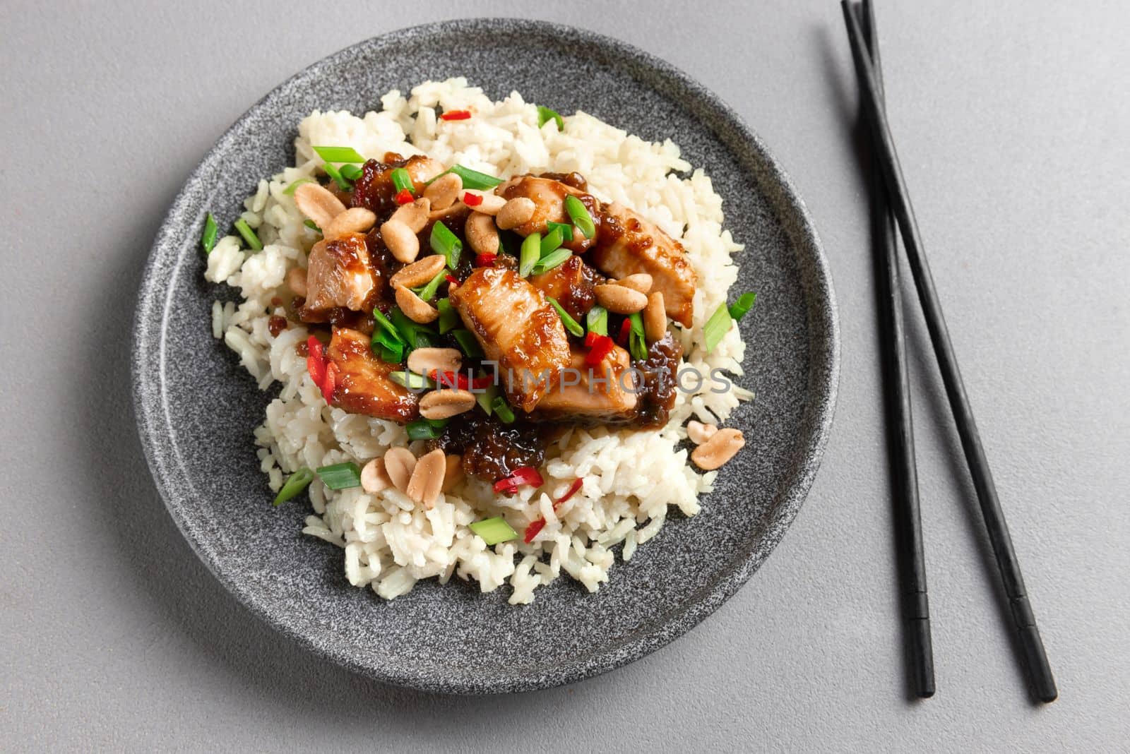 Asian Cuisine. Chicken Kung Pao dish with rice. Asian food on a gray background. Top view.