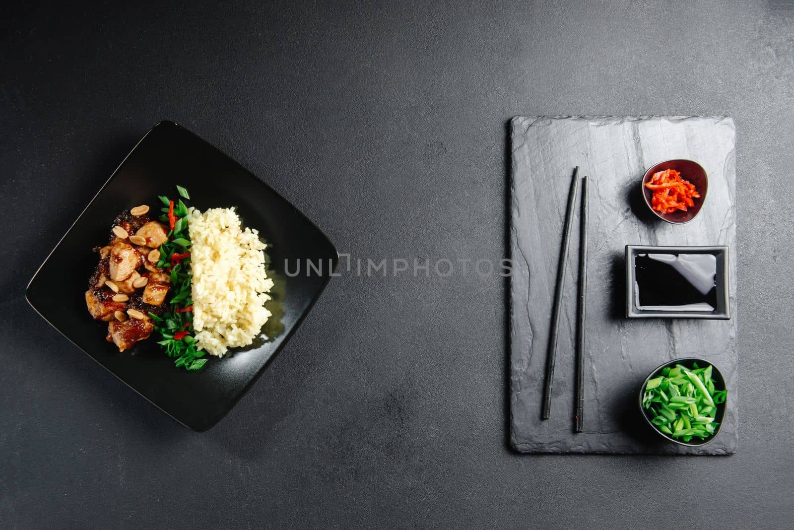 Asian Cuisine. Rice with chicken on a dark background top view. Boiled rice with stir-fried sliced chicken breast and basil.Thai cuisine by gulyaevstudio