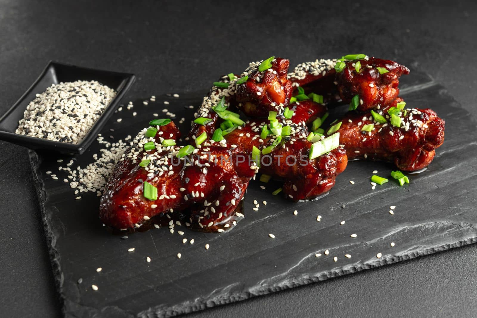 Chicken wings. Traditional asian recipe. Dark background. Top view. Chicken wings in teriyaki sauce. Asian chicken wings on a dark background. Chicken wings. Traditional asian recipe. Dark background. Top view. by gulyaevstudio
