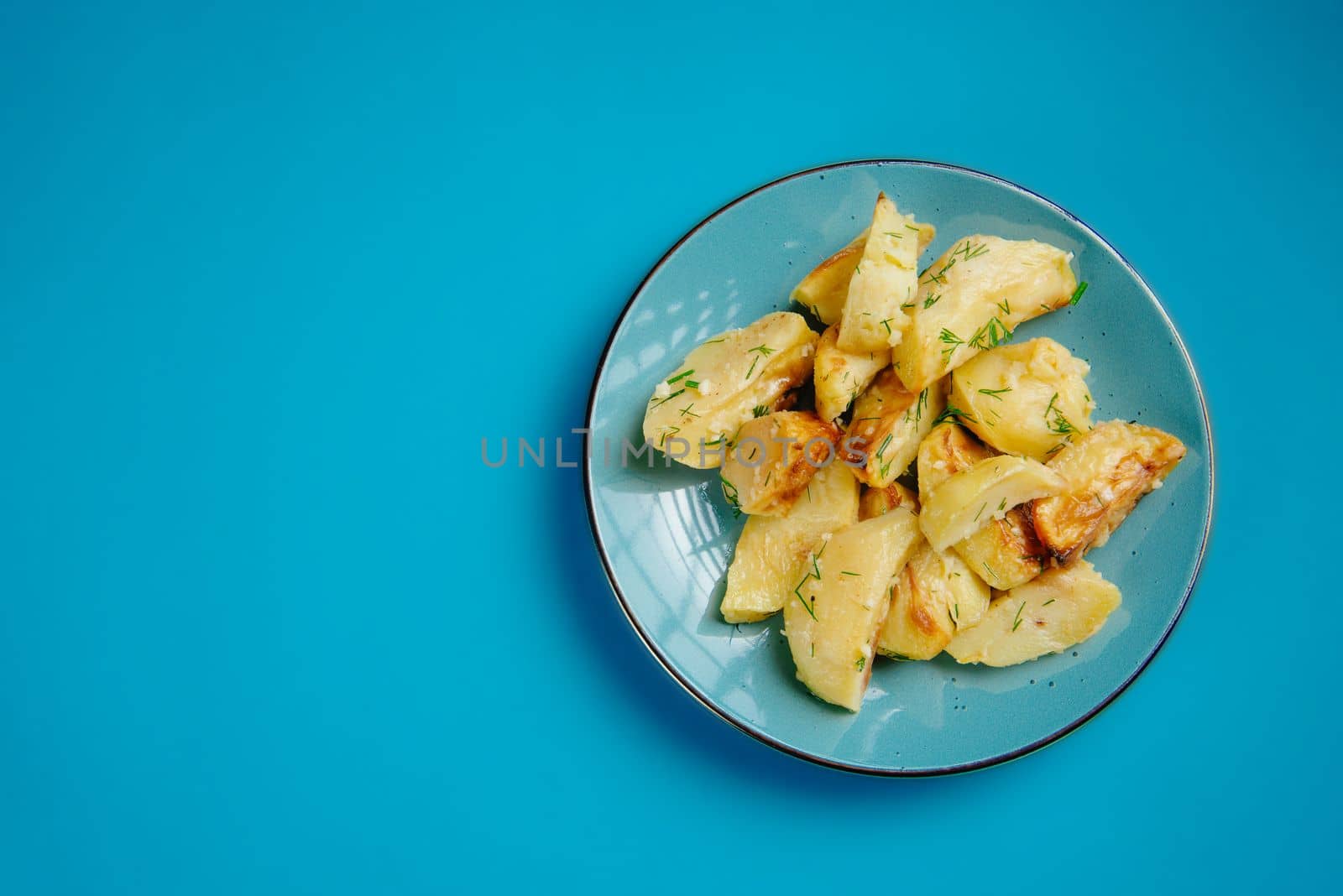 Healthy lifestyle, proper nutrition, ban on unhealthy foods.Fried potatoes in a plate on a blue background, blank space for text.Stop forbidden foods. by gulyaevstudio
