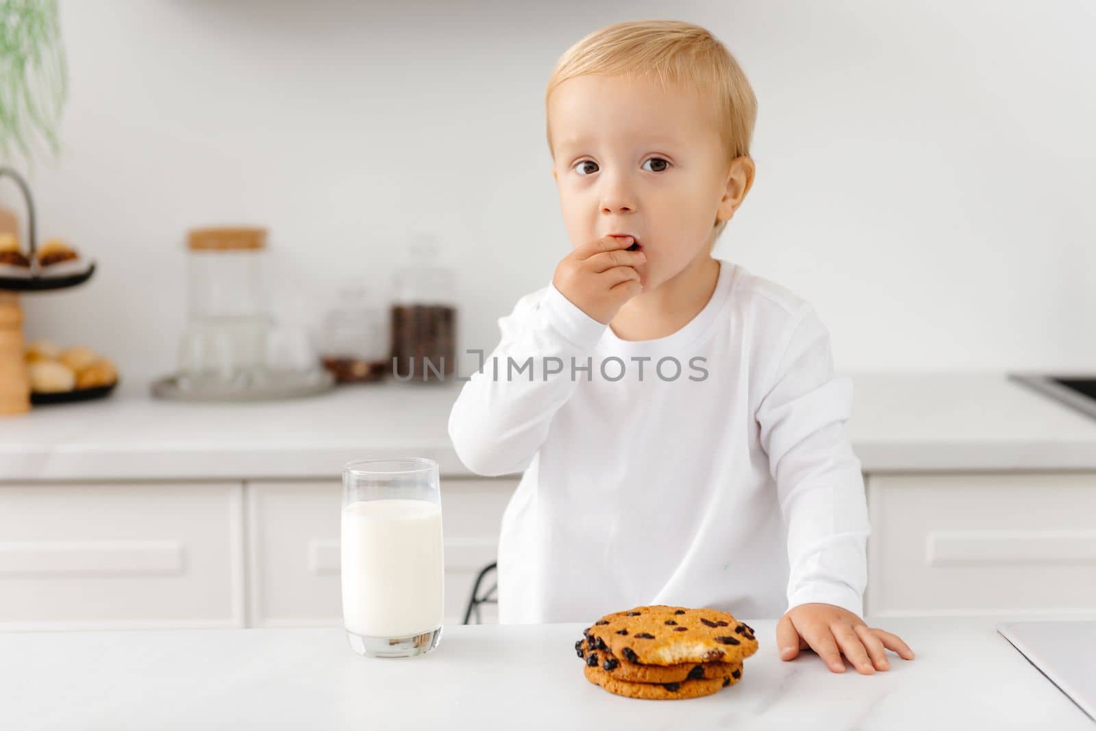 boy drinks milk and cookies in the morning. Oatmeal cookies with milk.