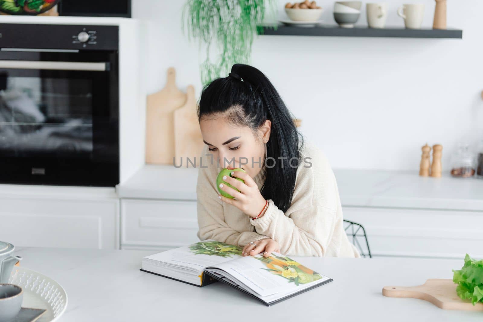 Healthy Eating. A young woman eats a lot of greens. Self-care. Woman reading a magazine about diet and healthy eating.
