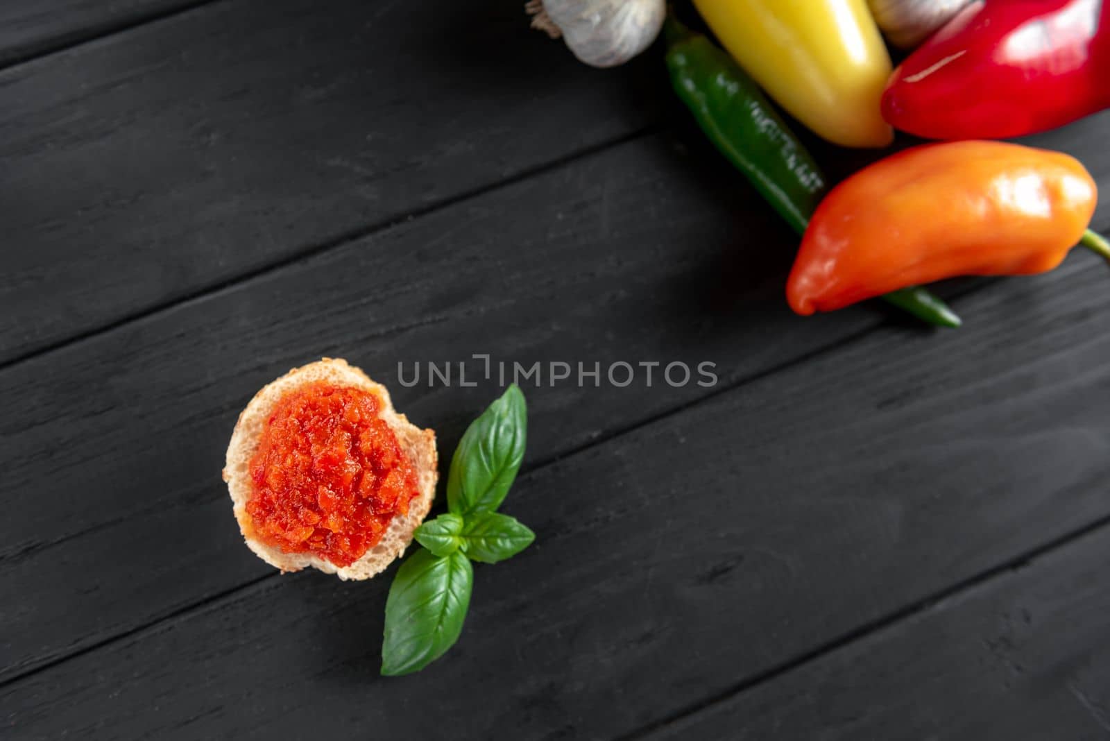 Toast chutney on a wooden background with vegetables in the background by gulyaevstudio