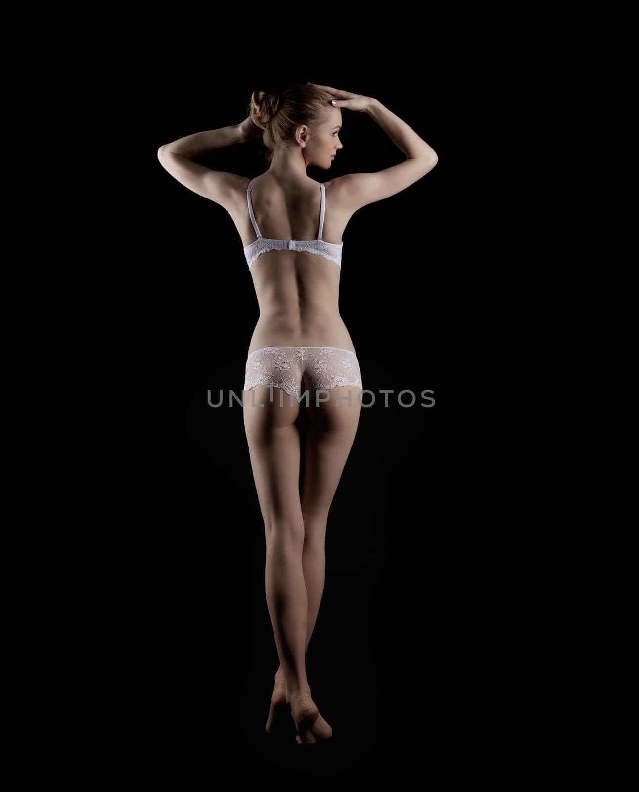 Attractive young woman stand in beauty white lingerie in dark