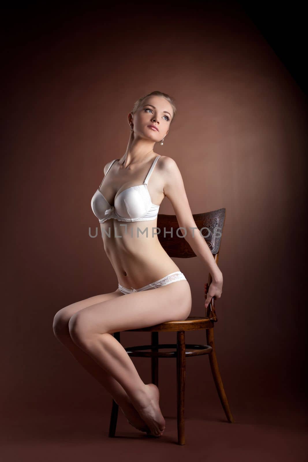 sexy woman portrait in white bra sit on old style chair