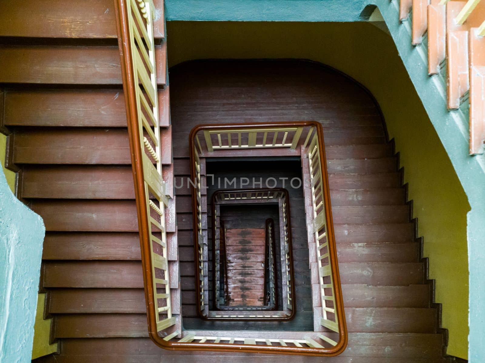 Interior of old renovated wooden square spiral staircase by Wierzchu