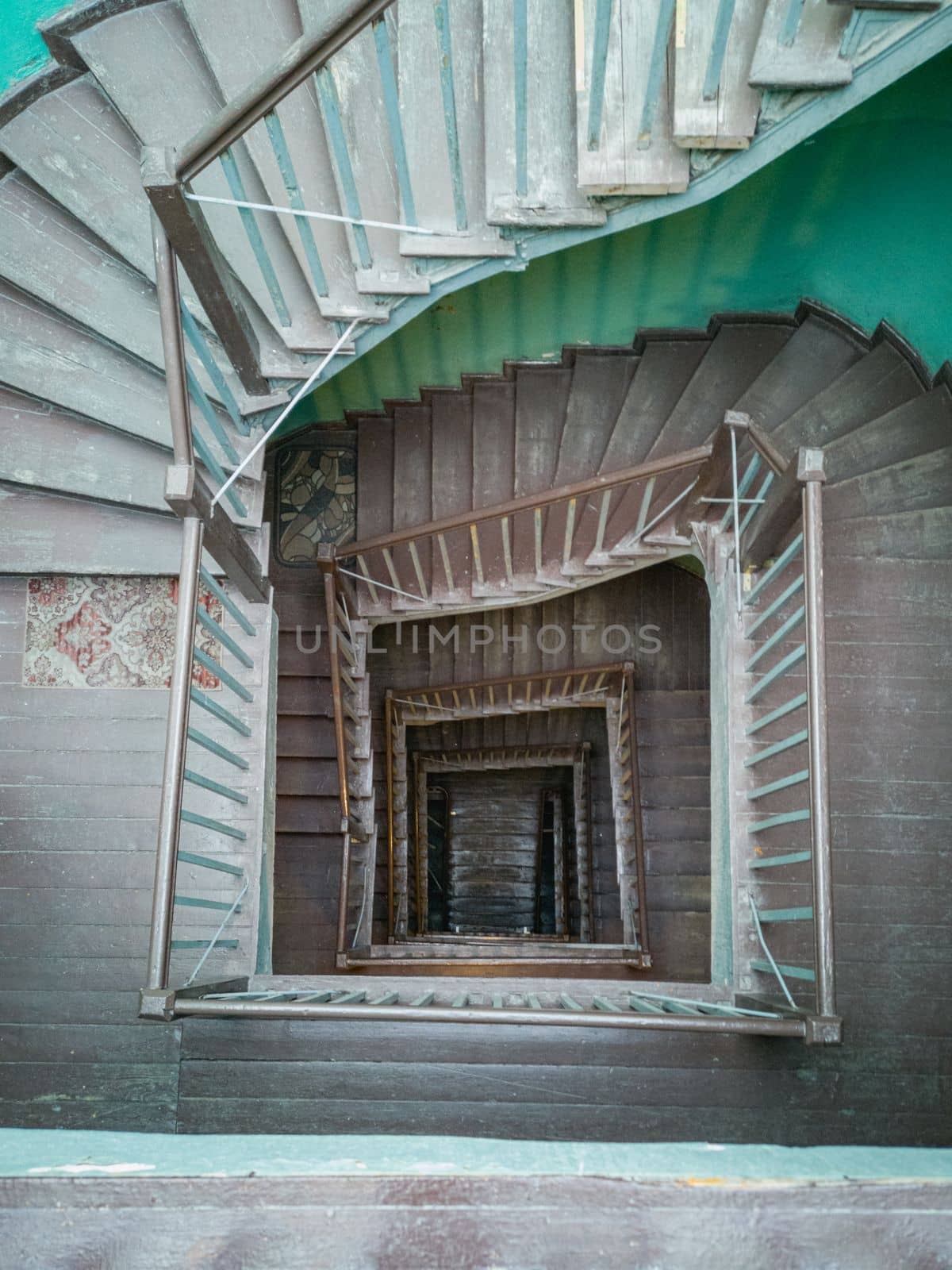 Interior of old renovated wooden square spiral staircase by Wierzchu