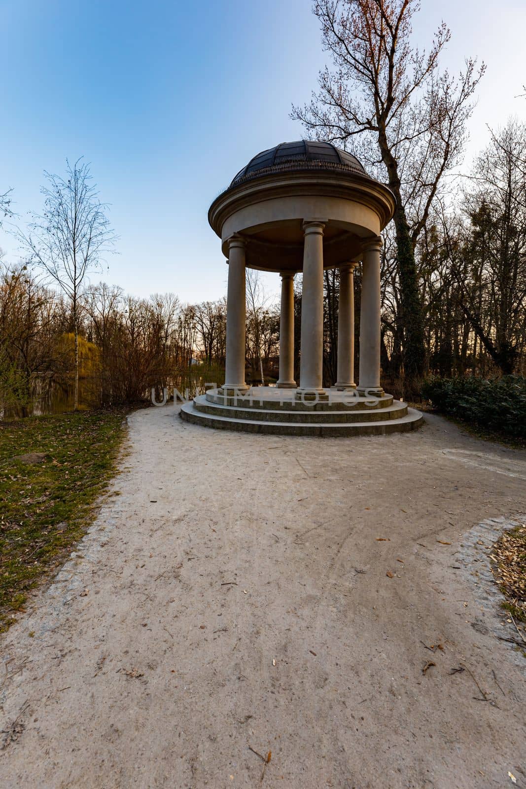 Small beautiful bower Glorieta at the edge next to small pond in park by Wierzchu