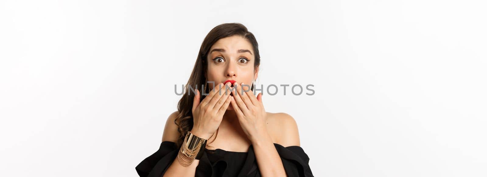 Fashion and beauty concept. Close-up of excited young woman looking amazed, cover mouth with hands and staring at camera with rejoice, white background by Benzoix