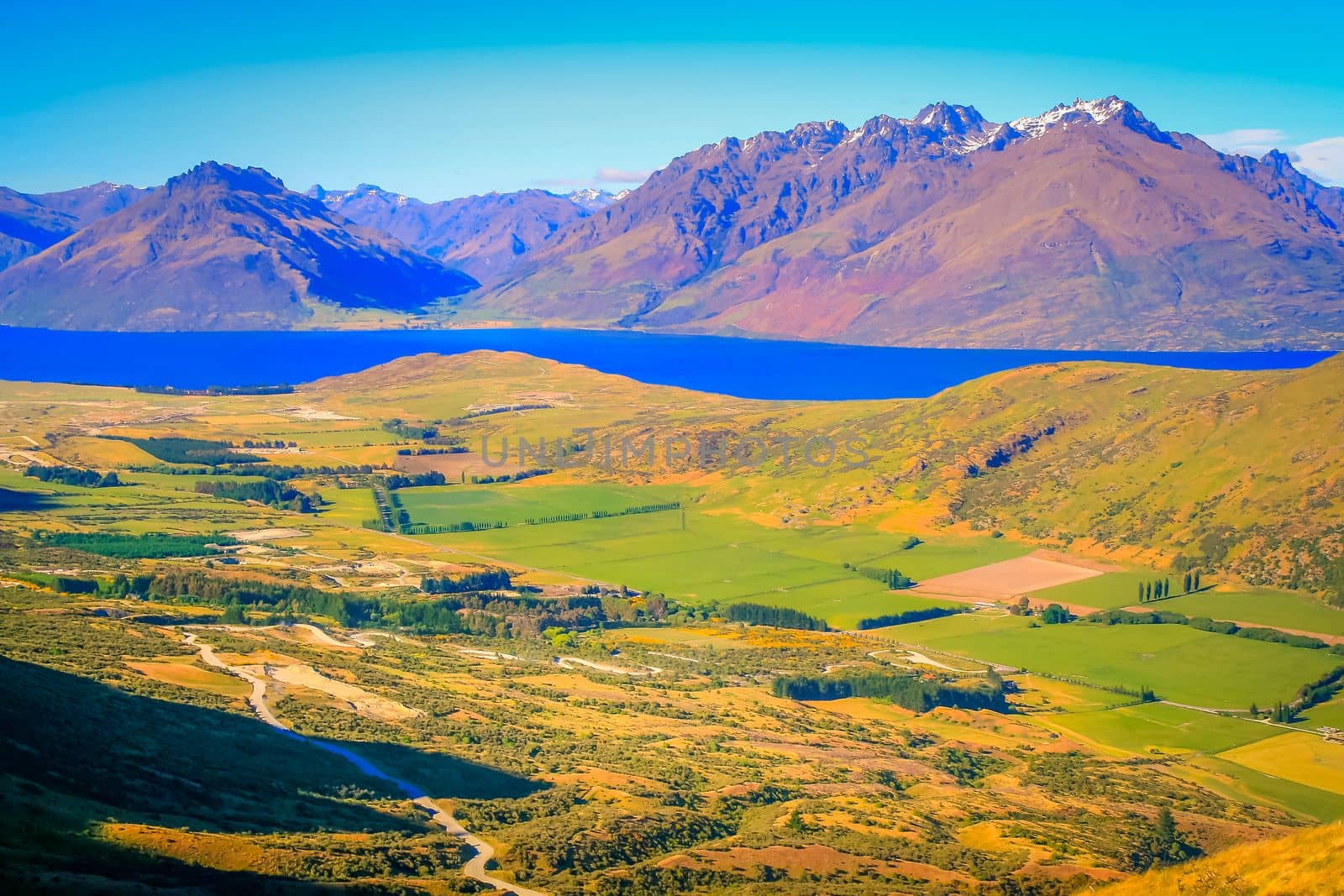 Above Queenstown and Lake Wakatipu coastline in south New Zealand at sunset,