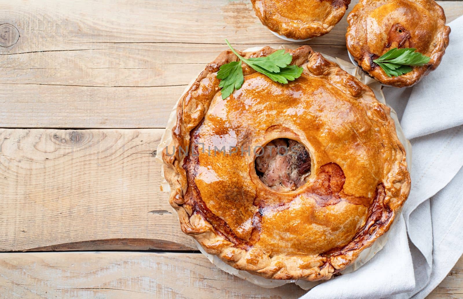 Autumn food. Homemade meat pie with greenery on wooden table, top view flat lay