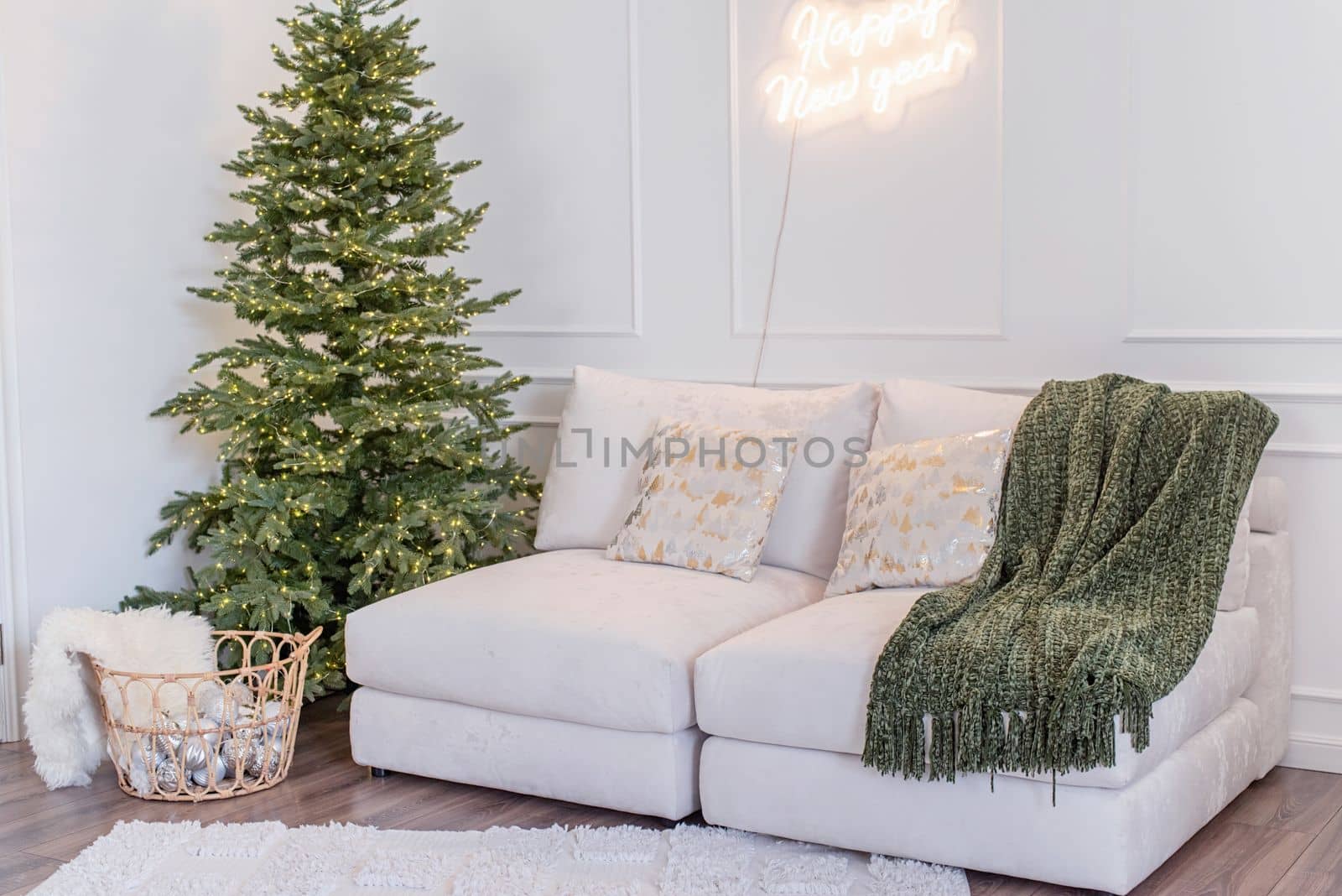 Merry Christmas and Happy New Year. Christmas tree with presents and lights in light and airy living room next to the window