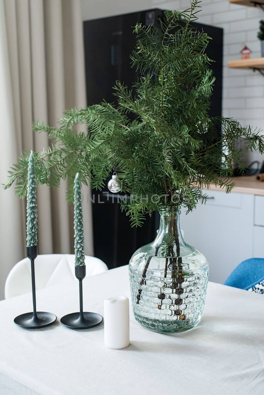 Merry Christmas and Happy New Year. Christmas tree with presents and lights in light and airy living room next to the window