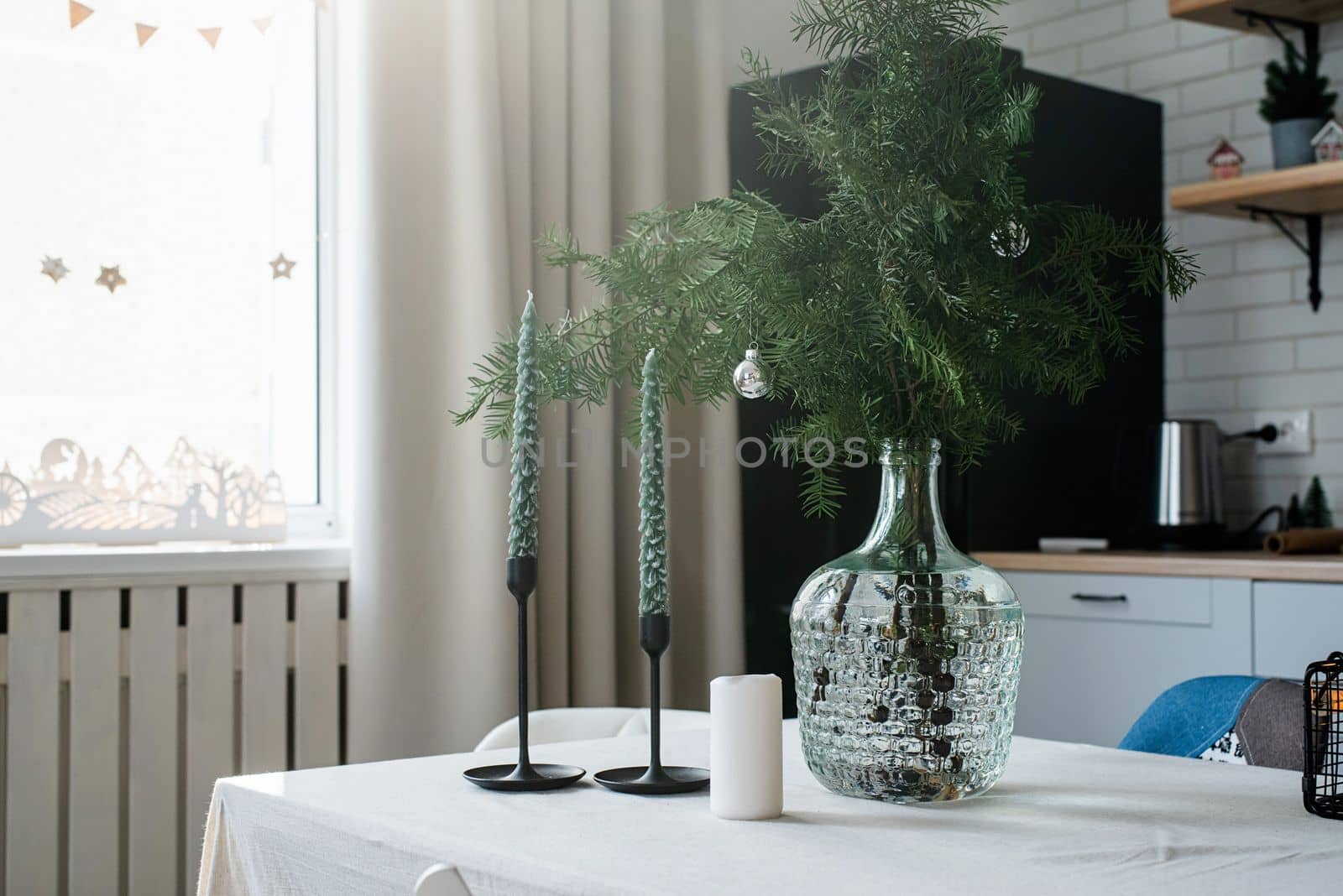 Merry Christmas and Happy New Year. Christmas tree with presents and lights in light and airy living room next to the window