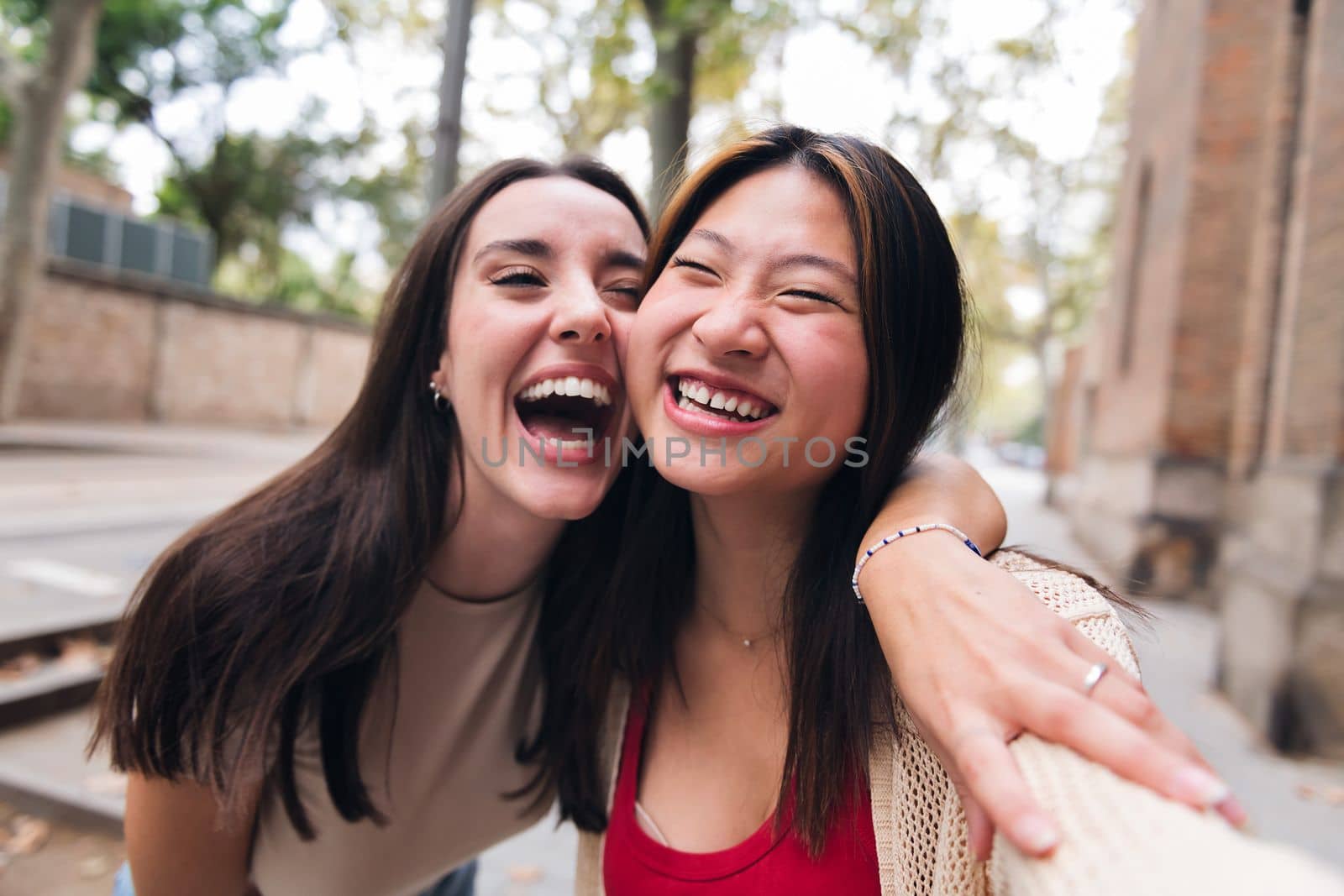 selfie of two young women laughing and having fun while dating, concept of friendship and love between people of the same sex