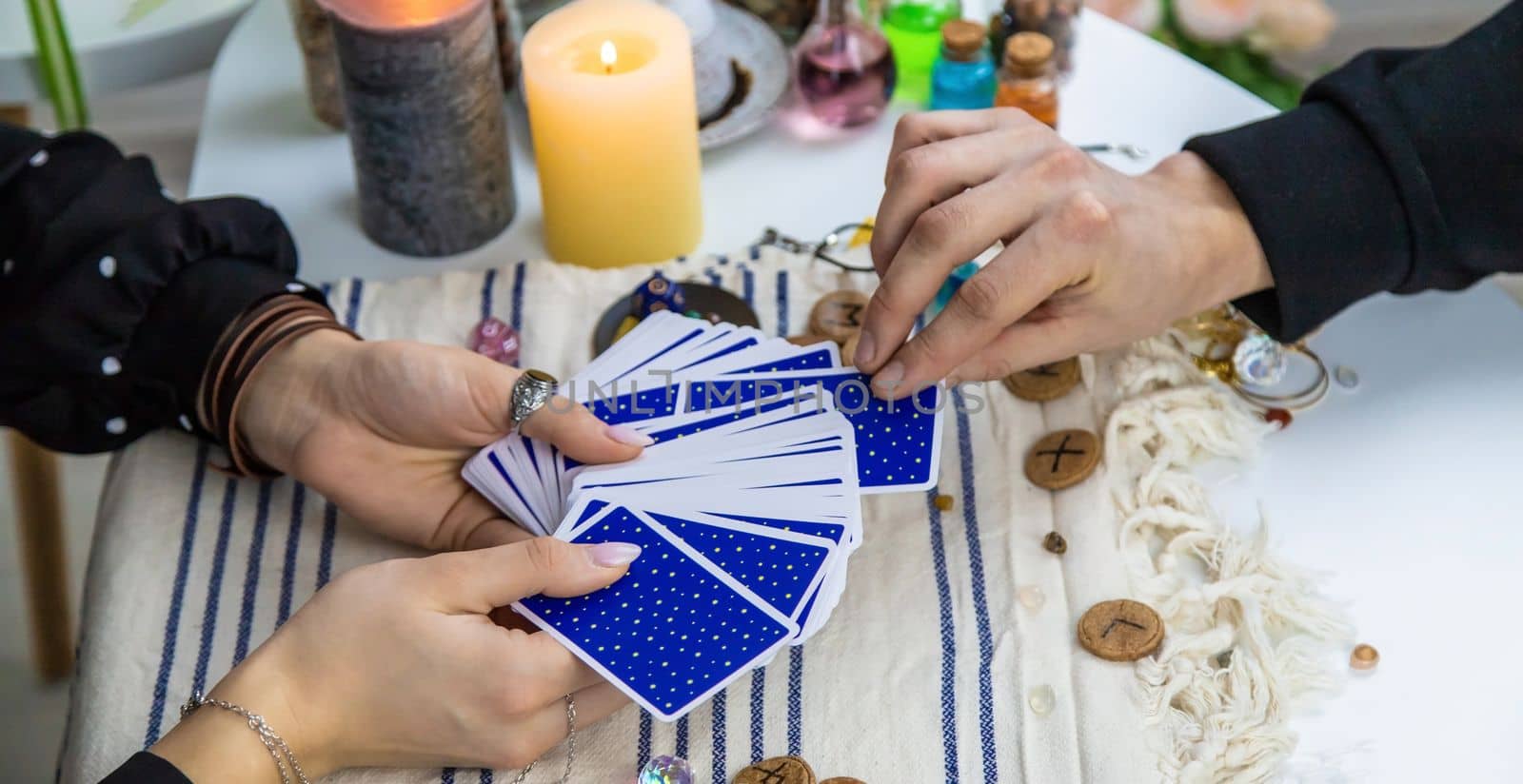 A woman fortuneteller tells a man on tarot cards. Selective focus. People.