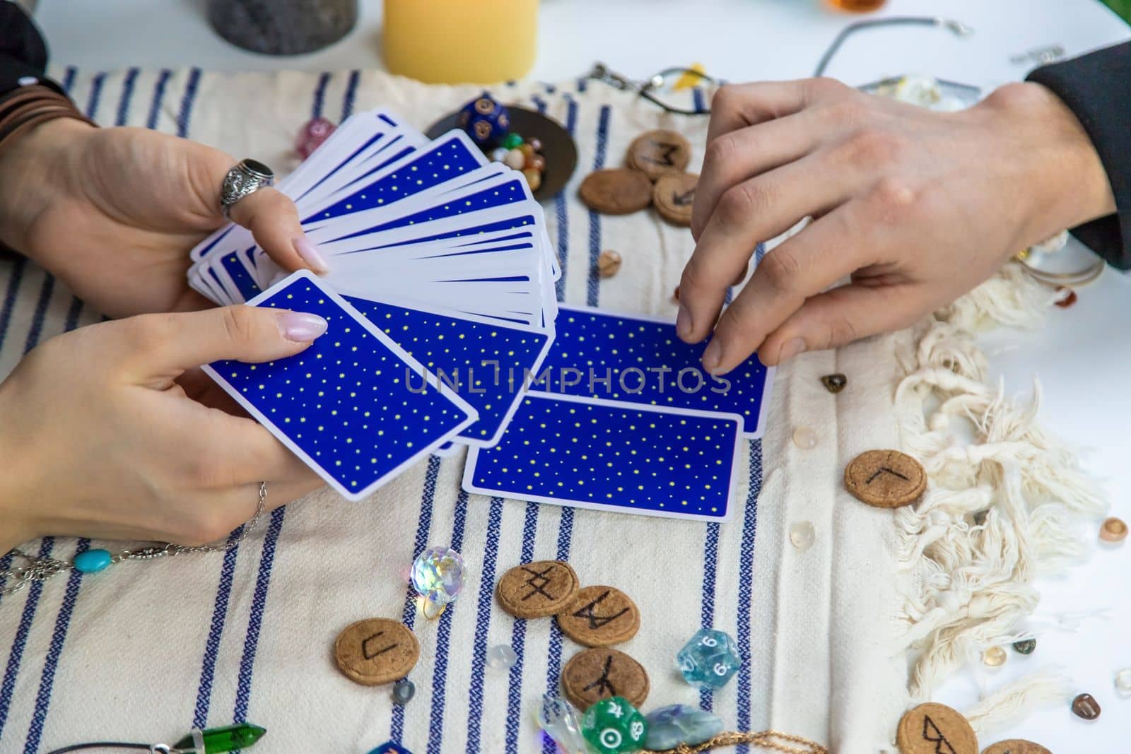 A woman fortuneteller tells a man on tarot cards. Selective focus. People.
