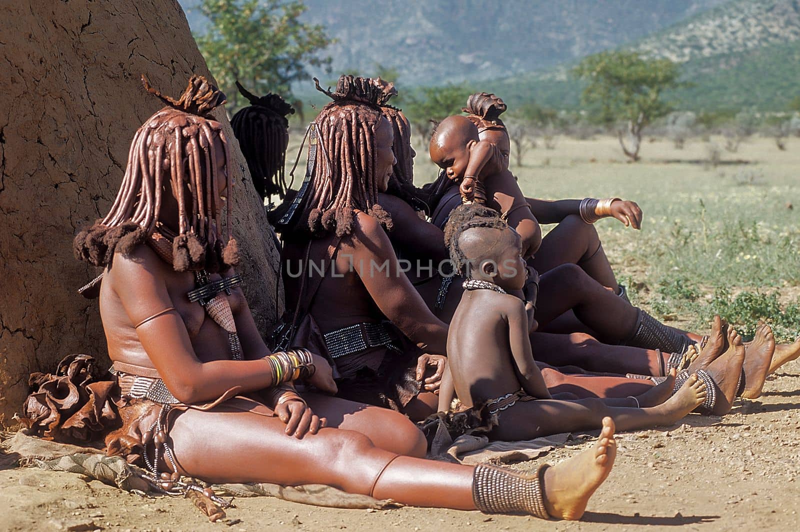 May 15, 2005. Himba women do not identify their children with traditional hairstyle, necklace and typical ocher skin. Epupa Falls, Kaokoland or Kunene Province, Namibia, Africa
