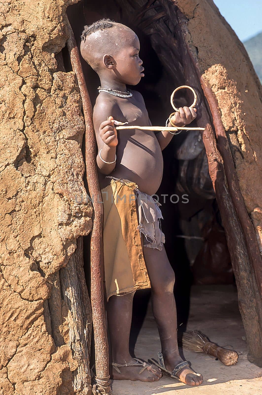 May 15, 2005. unidentified himba boy in the traditional hut, Epupa Falls, Kaokoland or Kunene Province, Namibia, Africa