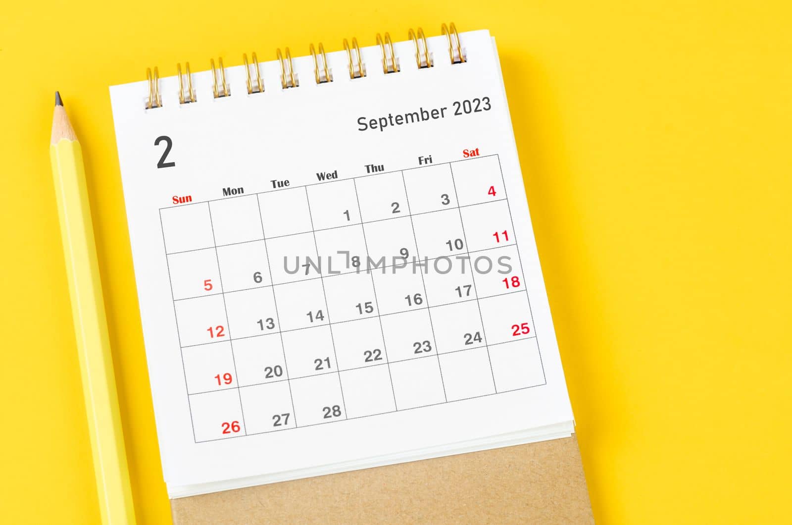 February 2023 Monthly desk calendar for 2023 with pencil on yellow background.