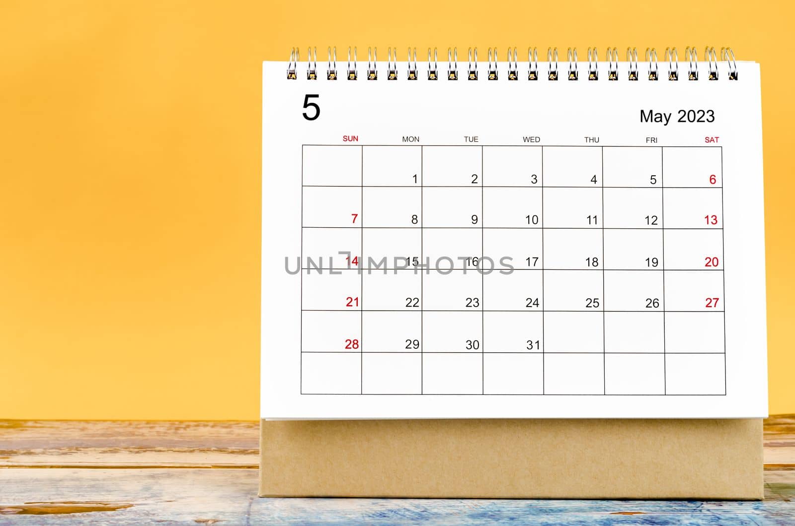 May 2023 Monthly desk calendar for 2023 year on yellow background.