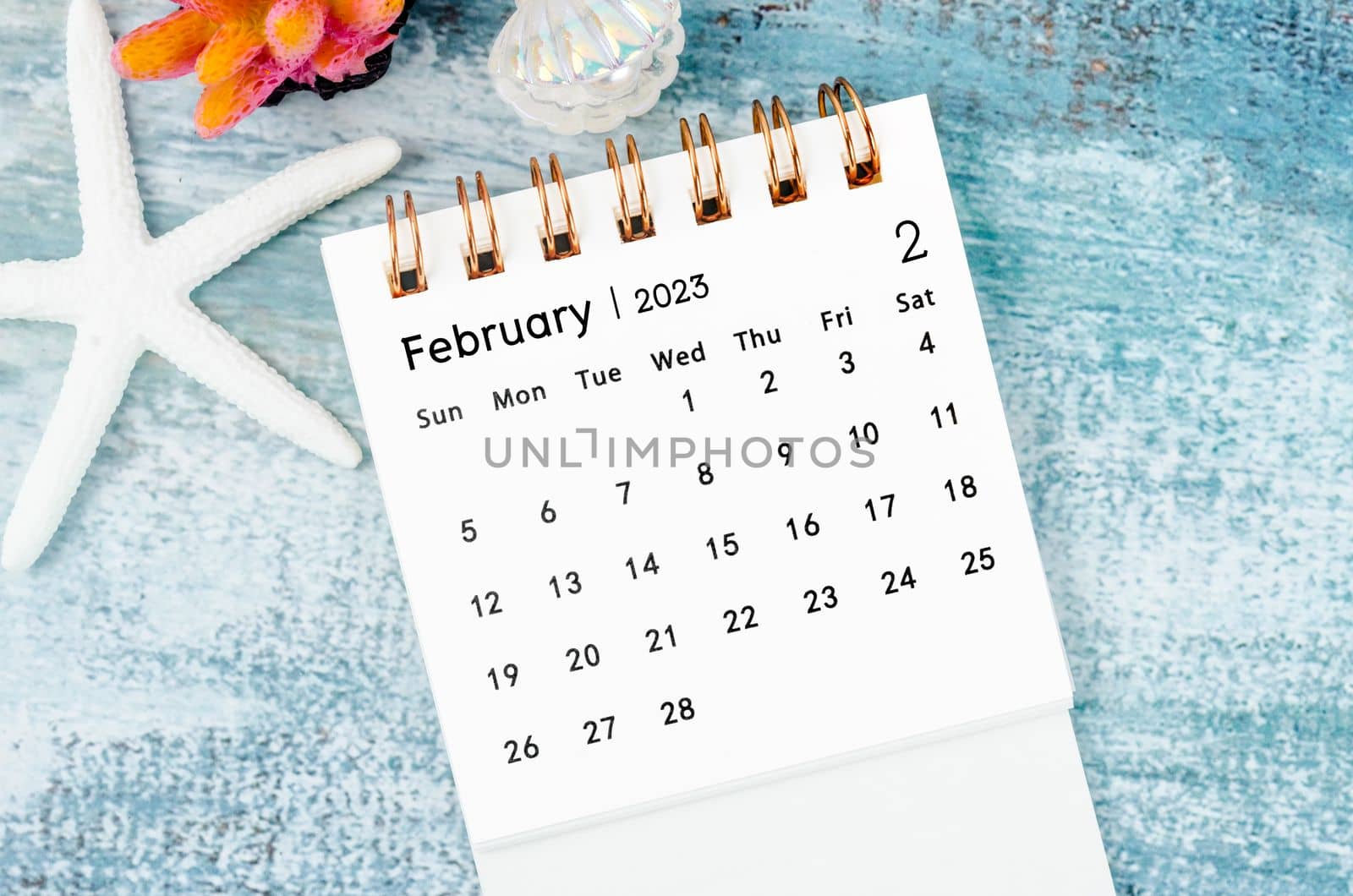 February 2023 Monthly desk calendar for 2023 year on old blue wooden background.