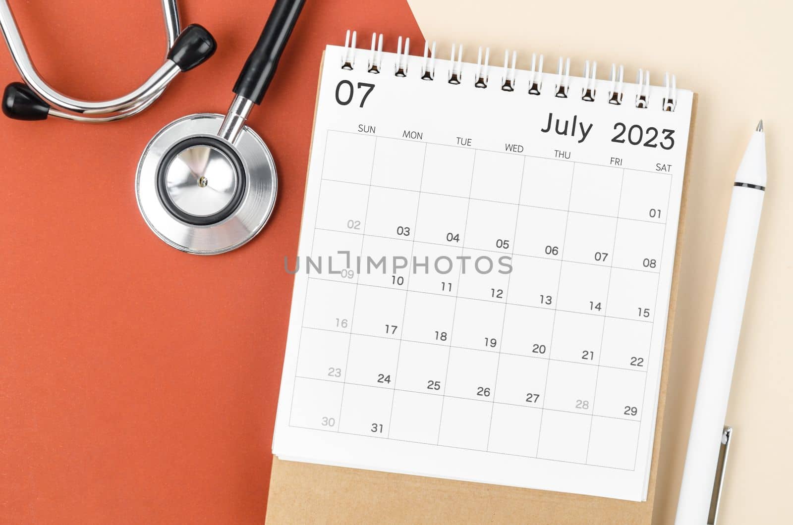 Stethoscope medical and July 2023 desk calendar with pen on the beautiful background, schedule to check up healthy concepts.