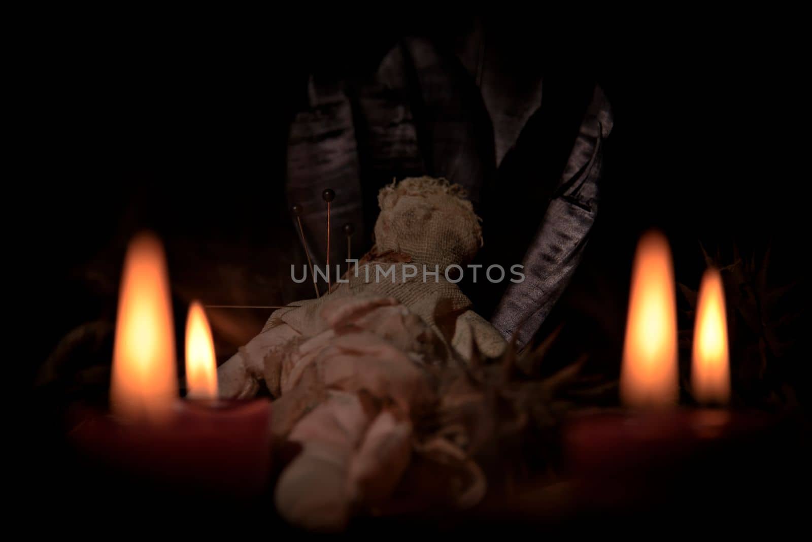 Voodoo doll, black candles, pentagram and old books on witch table. Occult, esoteric, divination and wicca concept. Mystic, voodoo and vintage background