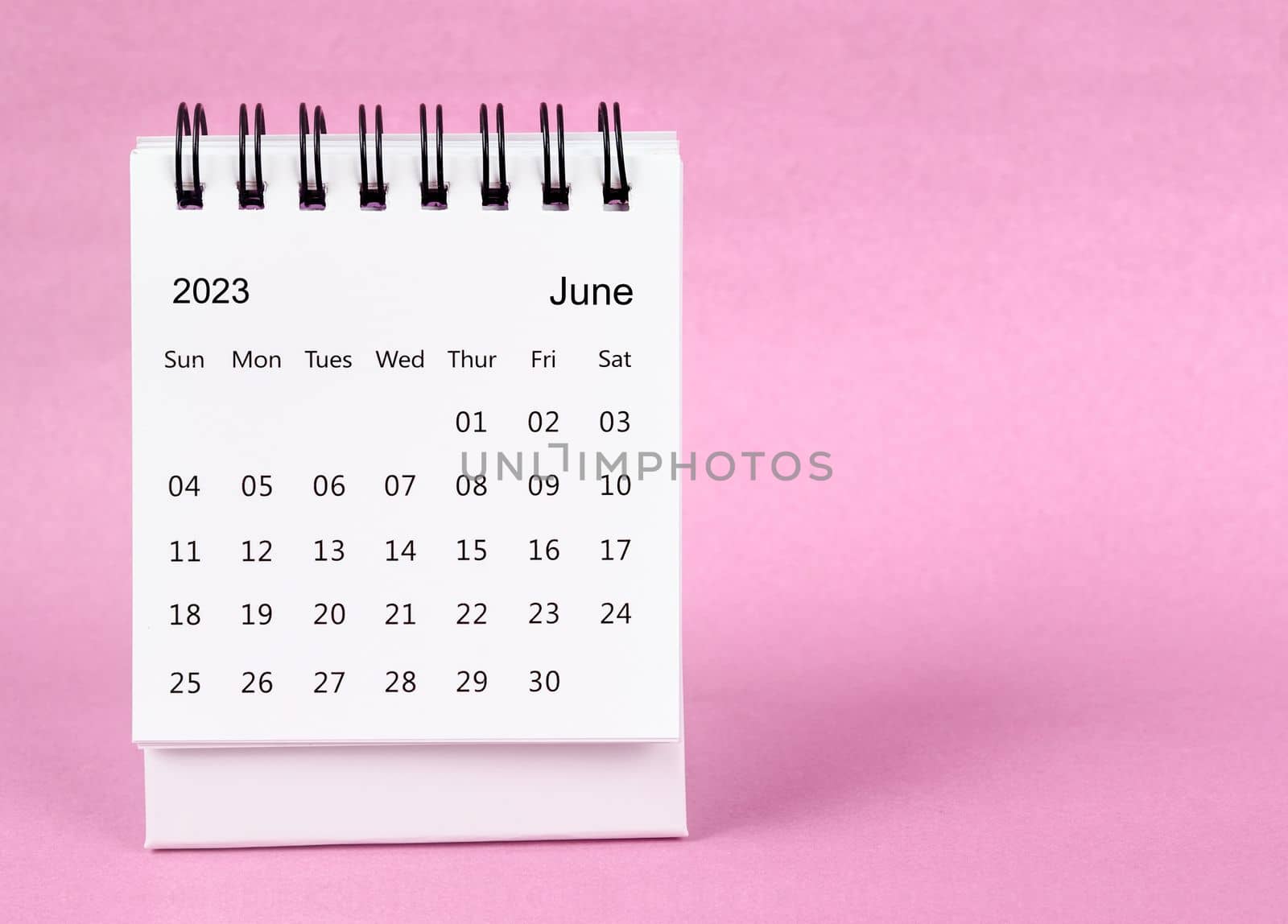 June 2023 desk calendar on pink color background.