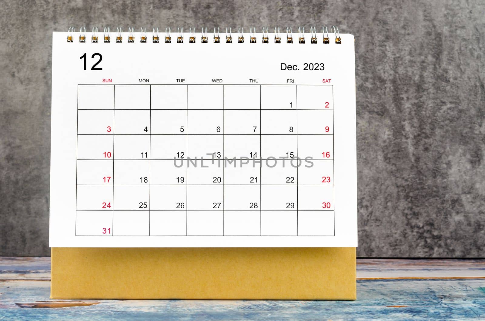 December 2023 Monthly desk calendar for 2023 year on wooden table.