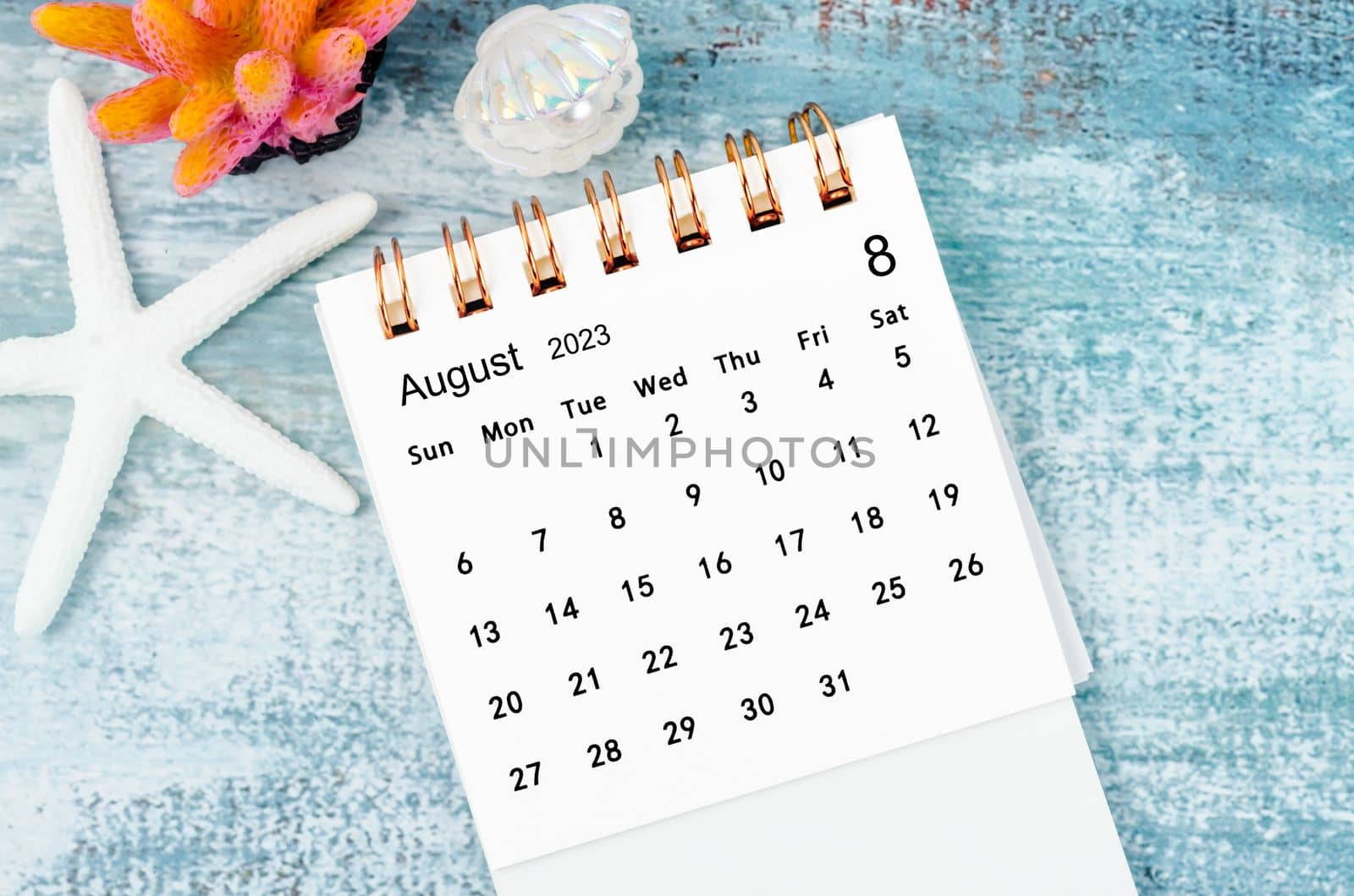 August 2023 Monthly desk calendar for 2023 year on old blue wooden background.